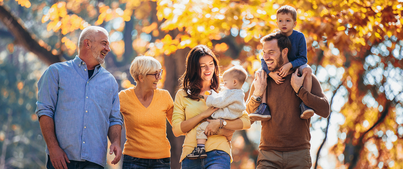 Three generations of a happy family walking outdoors after visiting dental office in Jacksonville