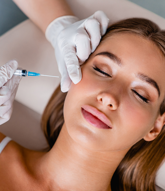 Woman closing her eyes while receiving a Botox injection in her cheek