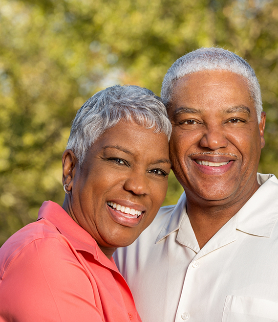 Older man and woman smiling together outdoors