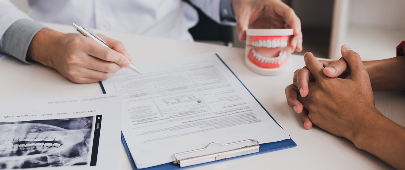 Two people looking at dental insurance paperwork at a desk