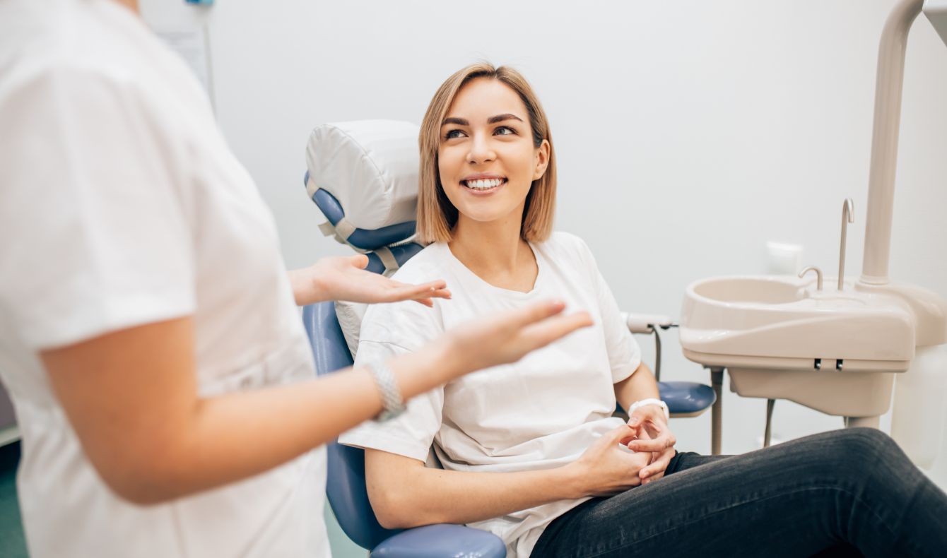 Woman in dental chair smiling up at her dentist in Jacksonville