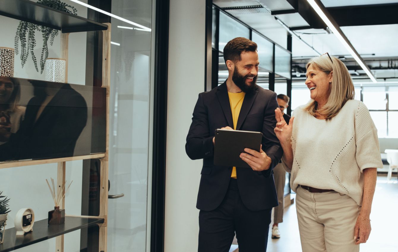 Woman and man walking down hallway of dental office and laughing