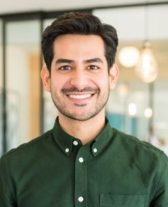 Man in green button up shirt smiling