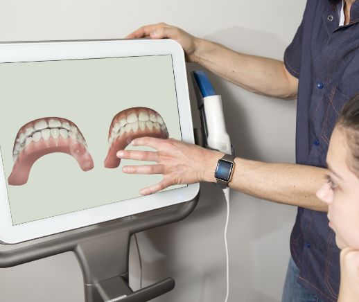 Dentist showing a patient a screen with digital scans of their teeth