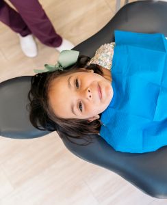 Young girl in dental chair looking up toward the camera