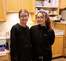 Two dental team members smiling in dental office