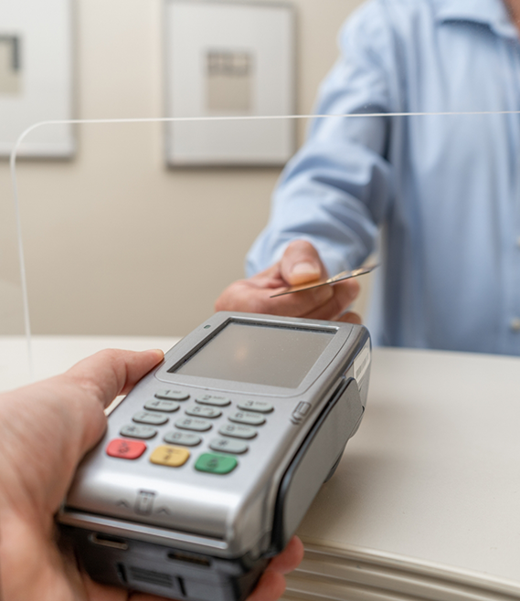 Person swiping their payment card at dental office front desk