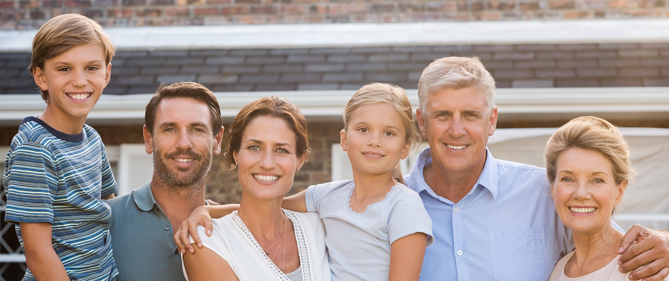 Three generations of a happy family in their front yard after receiving dental services in Jacksonville