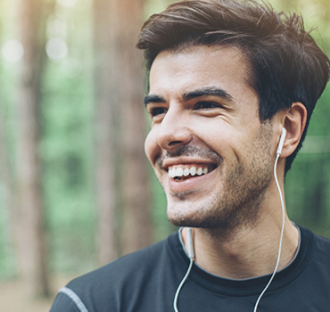 Smiling man wearing wired earbuds