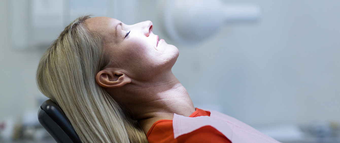 Woman leaning back and relaxing in dental chair thanks to sedation dentistry in Jacksonville